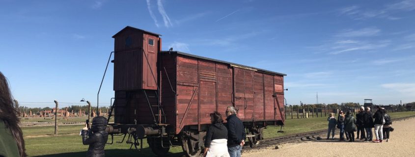 An old train car sitting on the tracks in Birkenau