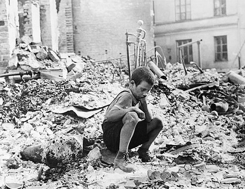 Polish boy in the ruins of the Warsaw, September 1939. Source, Julien Bryan captioned the photo in 1958: "A BOY'S WEARINESS--Ryszard Pajewski was a study in dejection when I saw him sitting on a pile of rubble. Only nine, he had suddenly been made the family breadwinner - and there was no bread to be had"