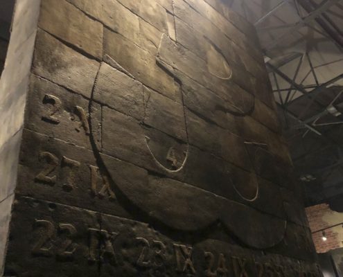 A ceaseless heartbeat pounds from central column in the Warsaw Rising museum, bearing the symbol of the Polish resistance