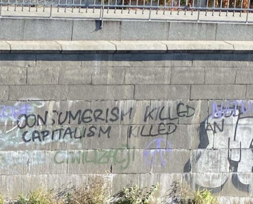 Consumerism Killed God (NATO written over), Capitalism Killed Man, in Wrocław, Poland. Photo By  Ian Eisenbrand.