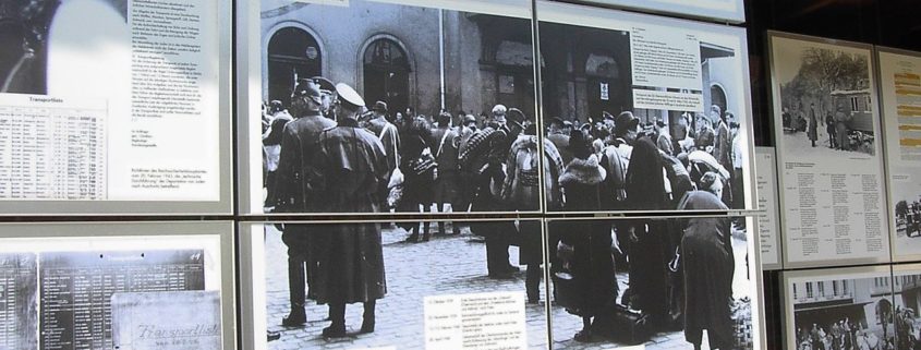 Image from the Topography of Terror Museum with a panel showing German Jews being deported to their deaths. Despite her insistence of being only an onlooker in the capturing of Jews, Stella Goldschlag was still responsible either directly or indirectly for hundreds of German Jews being sent to concentration camps and their eventual deaths. Photo credit: Public domain image by Adam Carr, posted on Wikipedia